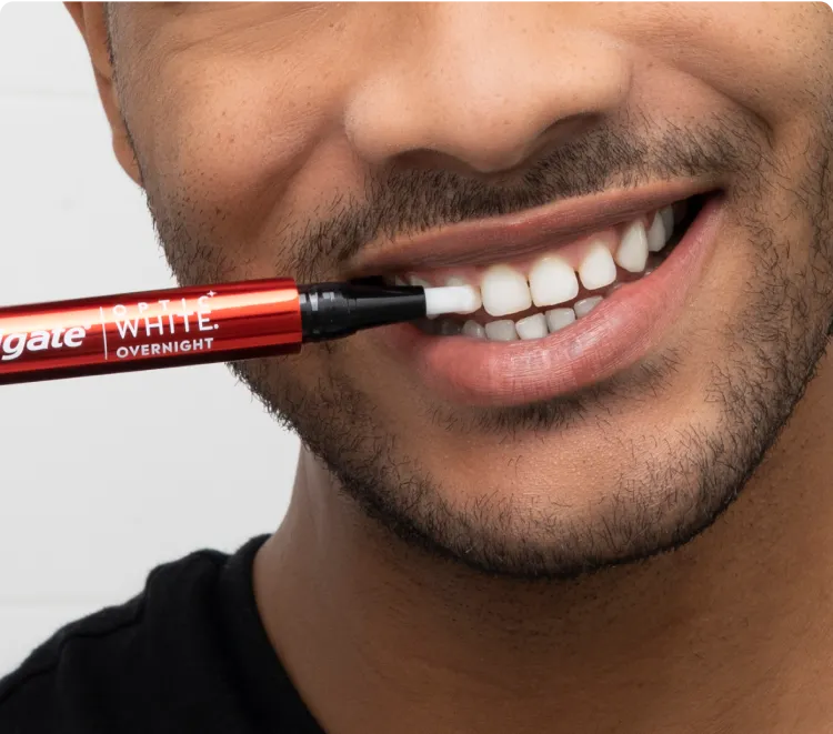 Man applying the Optic White Overnight Teeth Whitening Pen to his teeth