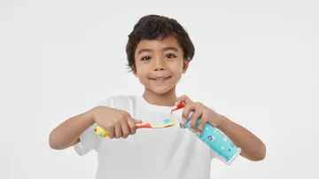 boy showing how to use hum kids smart manual coral toothbrush
