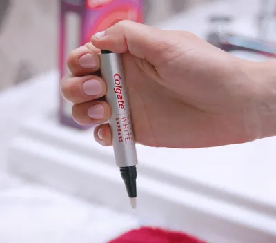 Woman's hand holding optic white express whitening pen